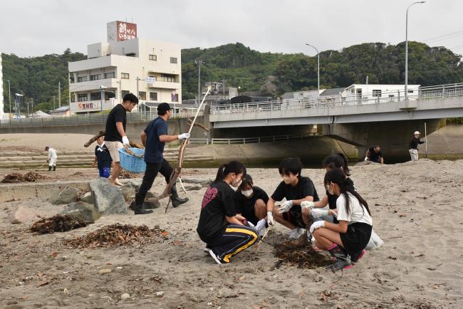 ごみを拾うこどもたちと木材を運ぶ男性