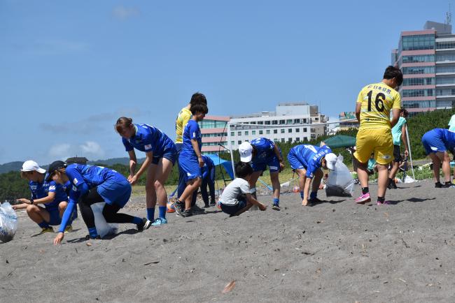 オルカ鴨川FCの選手とビーチスポーツ参加者のビーチクリーンの様子