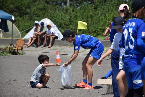 オルカ鴨川FCの接種とビーチスポーツ参加者のビーチクリーンの様子（アップ）