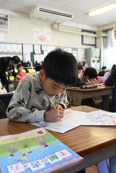 年賀状を書く男子児童