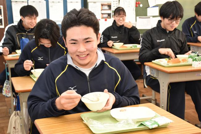 冬野菜のシチューを食べる男子生徒