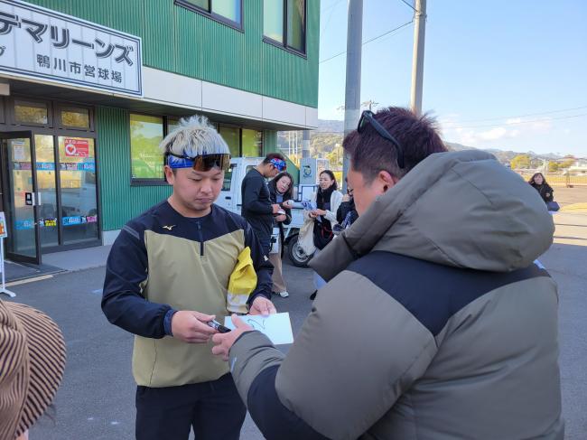 サインを書く佐藤選手