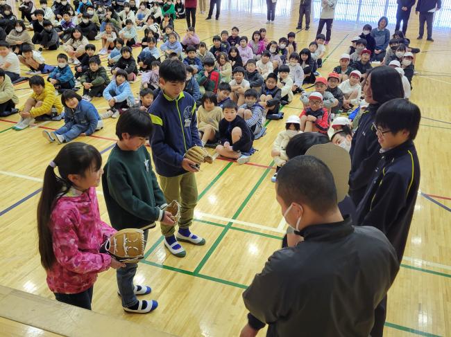 中学校の野球部から手渡される児童の写真