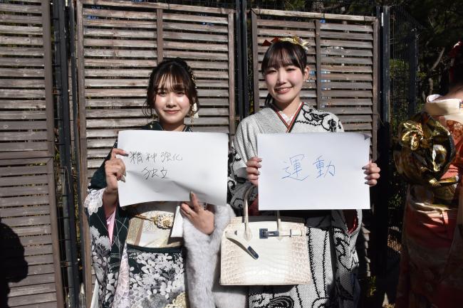 会場の外で二十歳の抱負を書いて写真を撮る女性2人