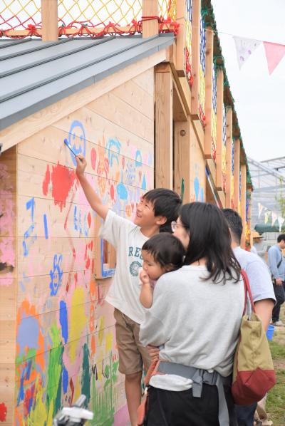 農園の小屋の壁を塗る男の子