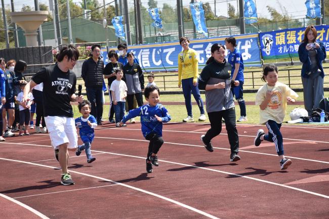 参加者と一緒に走ってフォームを確認する日本航空学園女子サッカー部の生徒