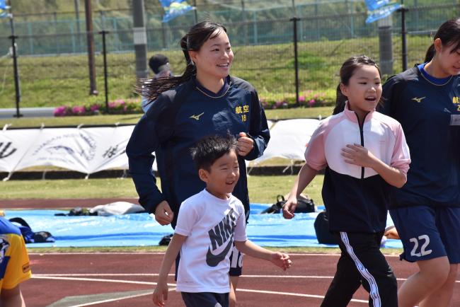 参加者と一緒に走ってフォームを確認する日本航空学園女子サッカー部の生徒2