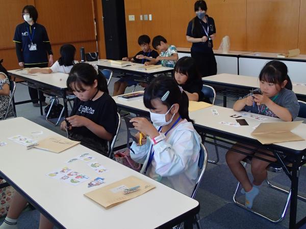 鴨川市のキャラクターマグネットを切り抜く子どもたち