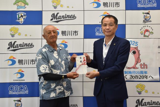 市長に寄附を渡す鴨川露天商代表の関氏