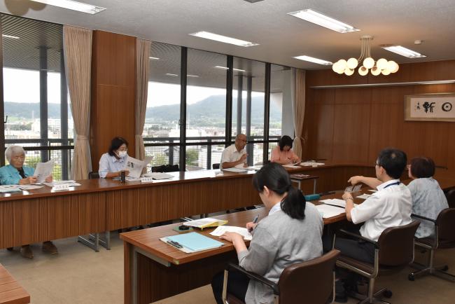 審議会を行う事務局と男女共同参画推進員の写真