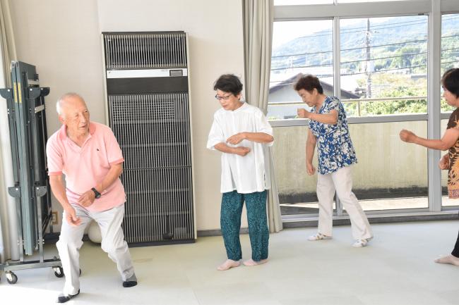 稲刈りの動作を踊る会員の写真