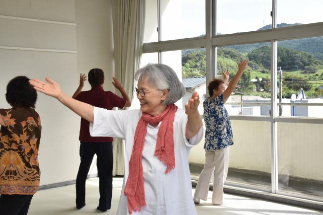 手を広げて長狭地区の発展を願う動きで踊る会員の写真