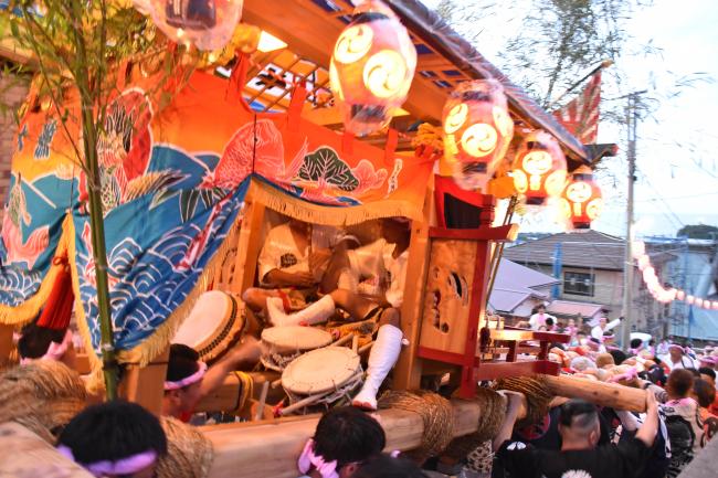 担ぎ屋台に乗って太鼓を演奏する奏者の写真