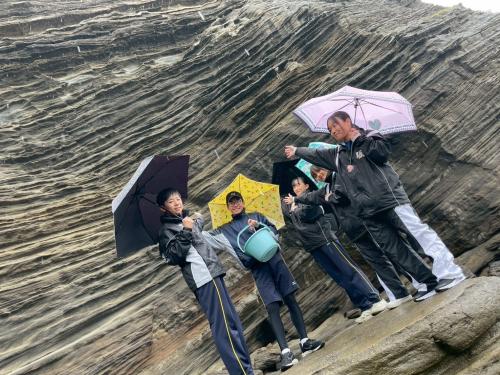 崖をバックに傘をさし
