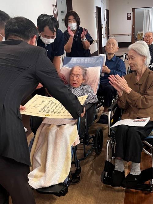 施設の皆さんから祝福を受ける 𠮷田 照子 さん