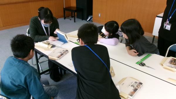 ブックカバーかけの説明をみる子どもたち