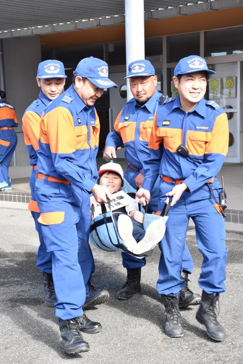 傷病者役の生徒を搬出する消防団員