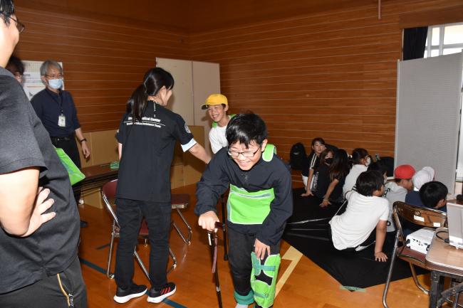 手足に重りをつけて高齢者の気持ちを体験する児童