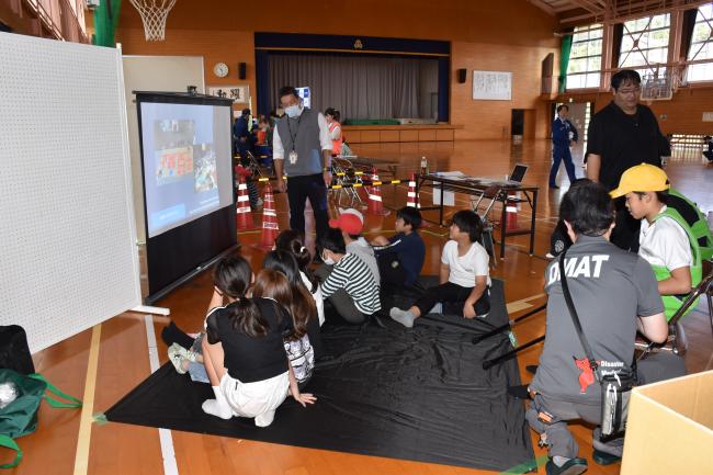 亀田総合病院のスタッフが説明するモニターを見る児童