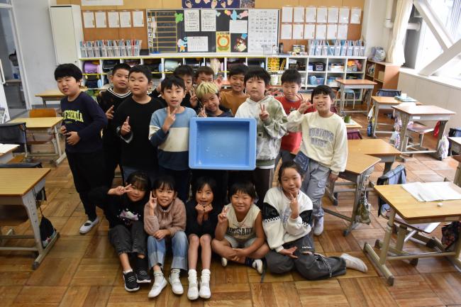 寄贈の新米長狭米をおいしく食べた江見小学校２年生がご飯の食缶をもって記念撮影