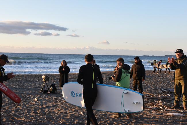 観客に見守られながら海へ向かう市長の写真