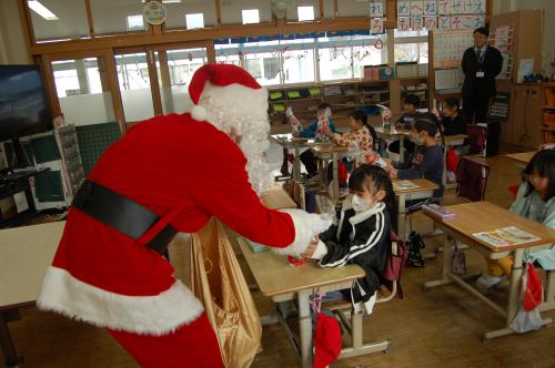 優しくプレゼントを渡すサンタさん