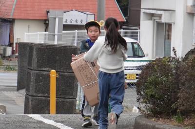 だんぼーるをもってとうこうするこども