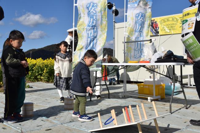 JR安房鴨川駅のブースで輪投げゲームをする子どもの写真