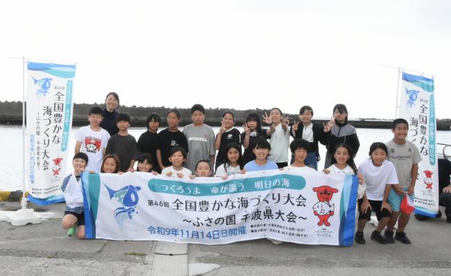 「全国豊かな海づくり大会」の旗を持った児童の集合写真