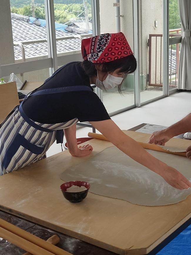 薄く伸ばしたそばを切るためにたたむところ