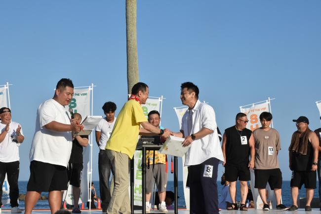 腕相撲大会で優勝して佐々木市長と握手をしている写真