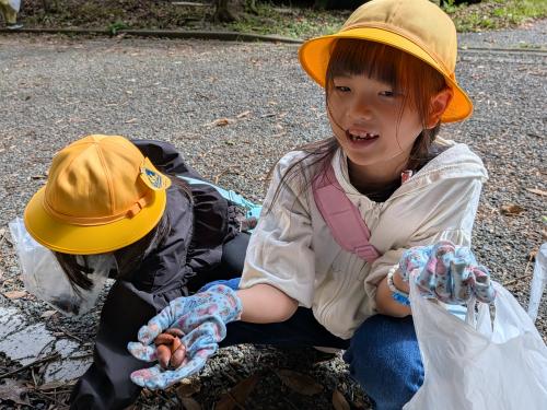 ドングリを片手に微笑む1年生