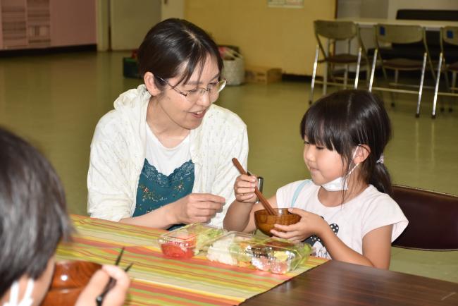 お弁当を楽しむ親子の写真