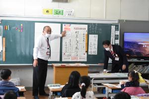 年賀状の書き方を説明する郵便局員