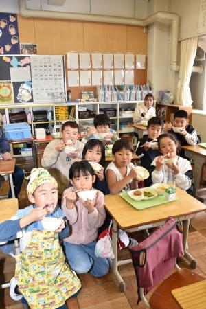 寄贈の新米長狭米をおいしそうにほおばる江見小学校２年生の児童たち